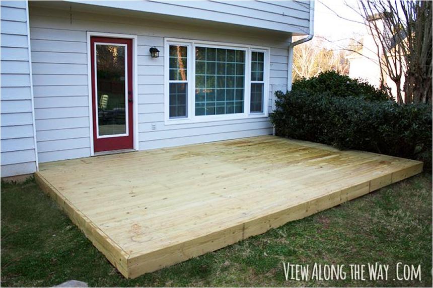 A newly built wood deck outside of a red door