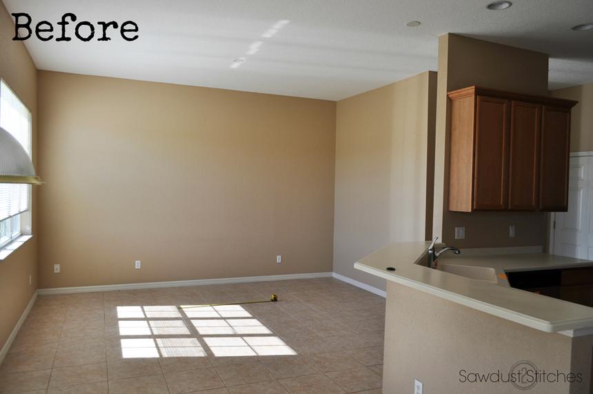 Dim carpeted living room next to kitchen