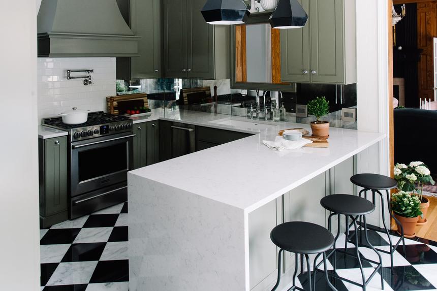 Updated kitchen with green cabinets, black and white floor