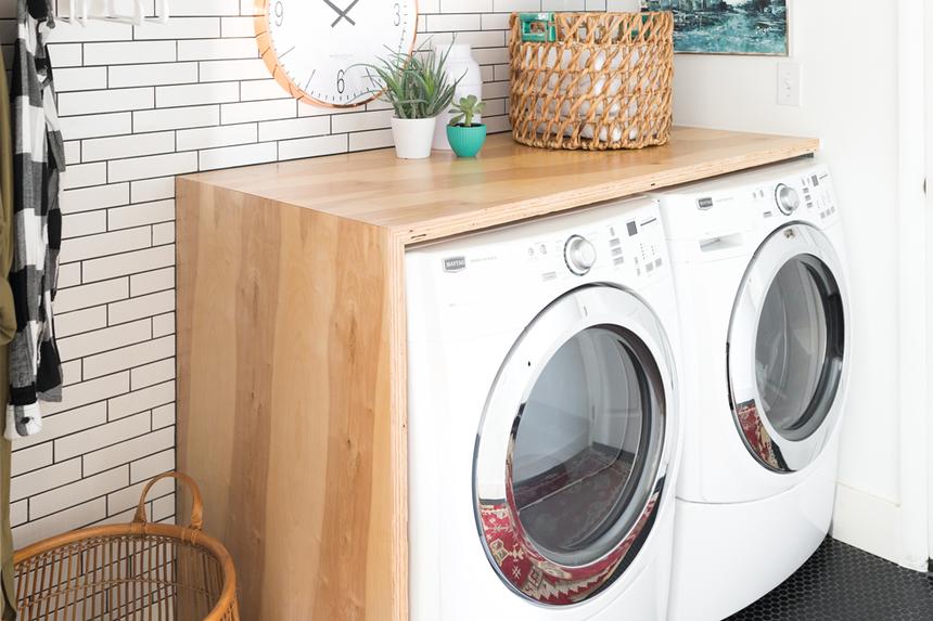 Laundry room with white subway tile and black tiled floor