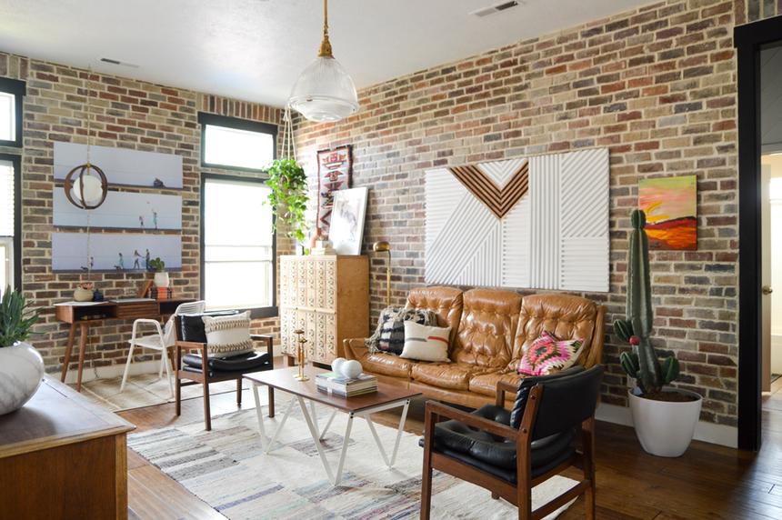 Bright living room with brick walls and wood floors