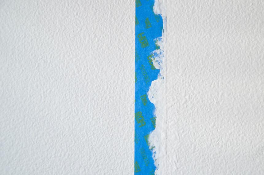 A white wall with blue paint tape
